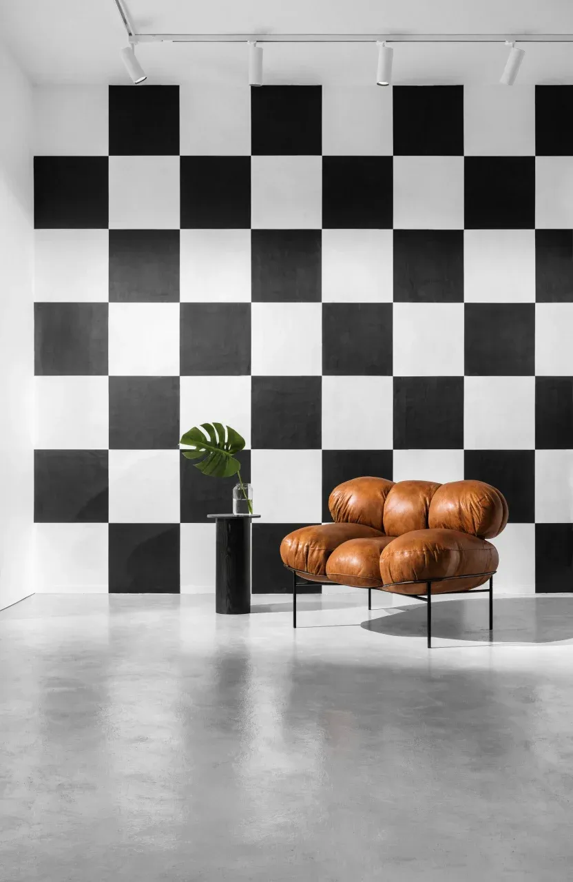 A bold living room with a large-scale black and white checkerboard wallpaper accent wall.