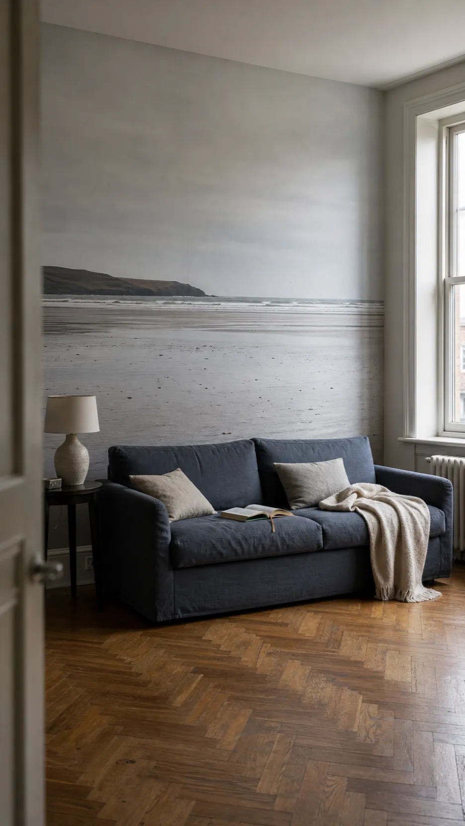 Minimal coastal living room styled around one beach mural without seashell decor