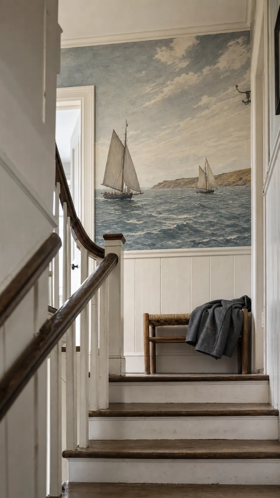 Traditional sailboat mural framed by cottage stair landing architecture