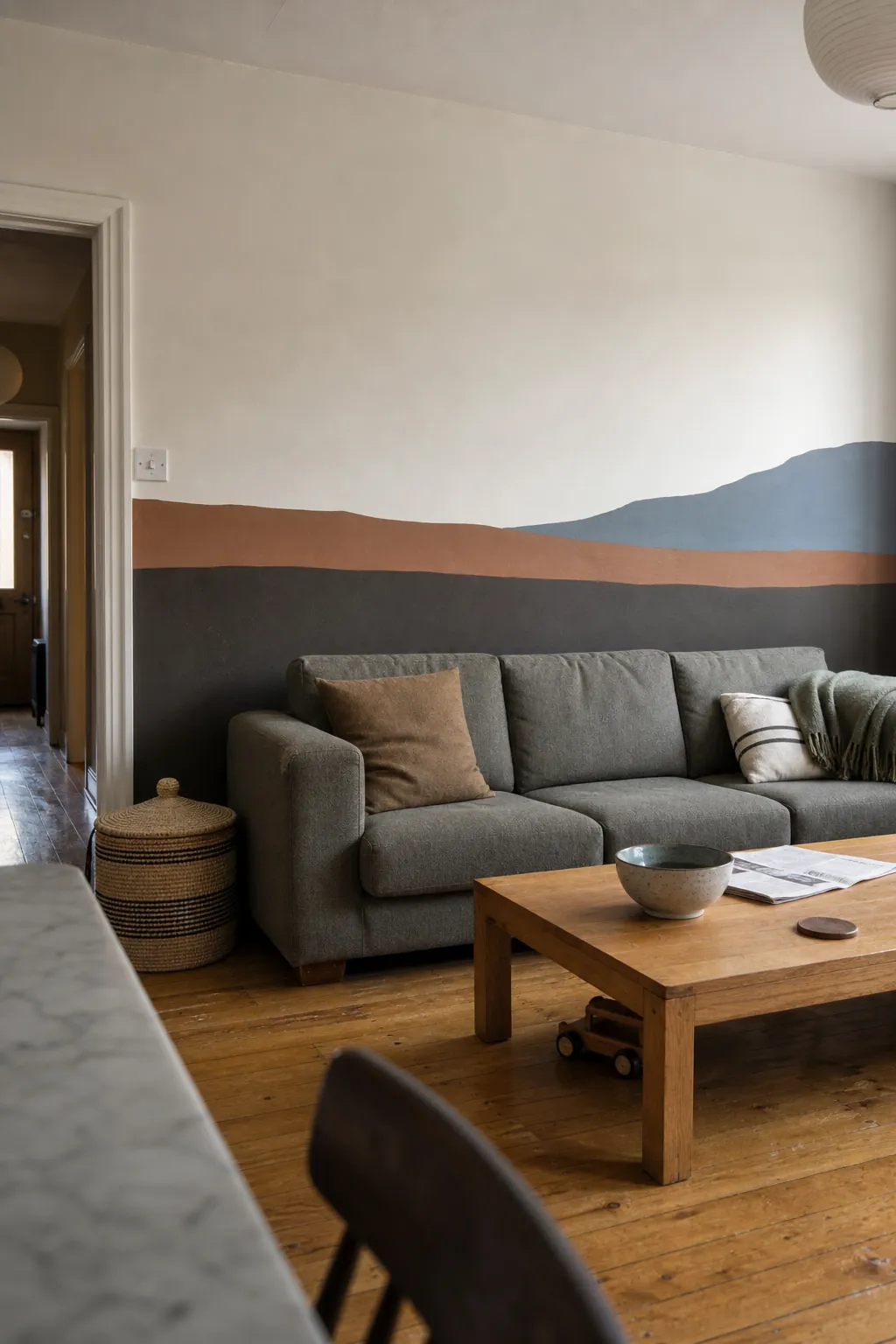 Abstract color-block landscape mural behind a living room sofa