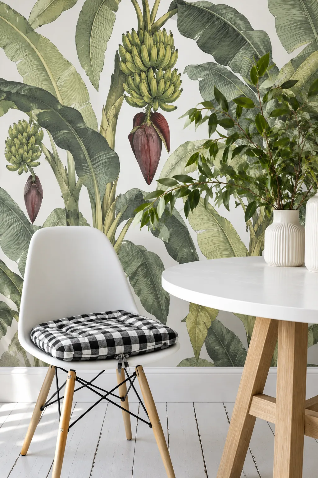White dining nook framed by an illustrated banana leaf mural.